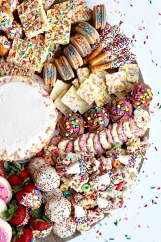 a platter filled with lots of different kinds of cookies and pastries on top of it