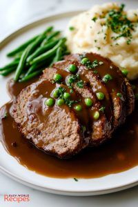 meatloaf with gravy, mashed potatoes and green beans on a plate