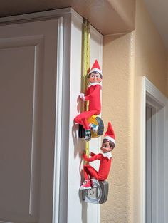 two elfs are climbing up the side of a door with a tape measure on it