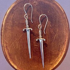 Crafted in sterling silver and 14k gold vermeil, these swords are lightweight and wearable! The texture and detail on these shimmer magically in the light. The swords add length and dimension to your face. 14k yellow vermeil and sterling silver Sword measures approx. 35mm in length Available on 14k gold fill ear wire Wear with our Sword Necklace with Ruby Because our jewelry pieces are all made entirely by hand, we can offer a wide array of customization! Click here to inquire about this design Ear Wire, Swords, Custom Engraving, Gold Vermeil, Jewelry Pieces, Gold Filled, Anthropologie, Ruby, Texture