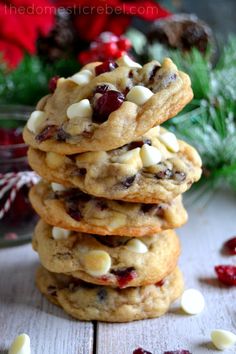 white chocolate cranberry cookies stacked on top of each other in front of christmas decorations