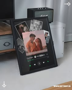 there is an electronic photo frame with pictures on it and two speakers next to it