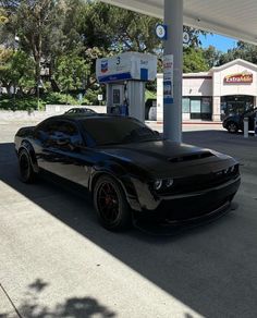 a black sports car parked at a gas station