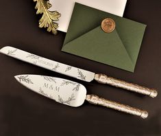 two knives are sitting next to each other on a table with an envelope and wax stamp