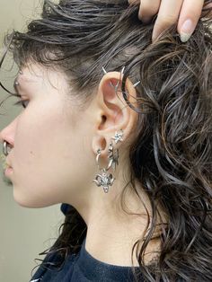 a woman is getting her hair styled by another person with curly hair and silver earrings