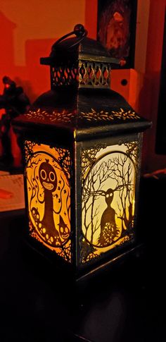 a decorative lantern with an image of a cat in the forest on it's side