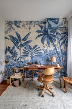 a room with a desk, chair and wallpaper in the shape of palm trees