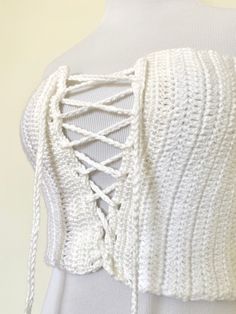 the back of a white knitted top with laces and crochet on it