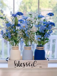 three vases with blue and white flowers in them