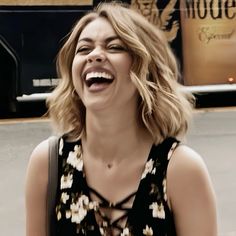 a woman laughing while walking down the street