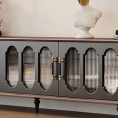 the sideboard is made from metal and has glass doors on each side, along with a busturine