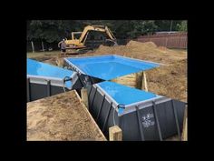 an image of a construction site with blue tarps on the ground and bulldozers in the background