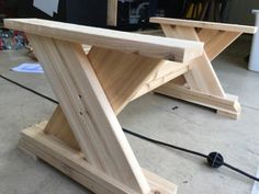 a wooden table sitting on top of a floor next to a black corded mouse