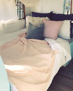 a bed with many pillows and blankets on it