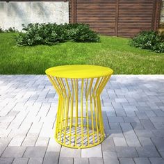 a yellow table sitting on top of a brick patio