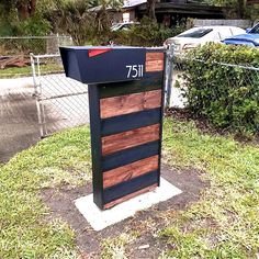 a mailbox sitting in the grass near a fence