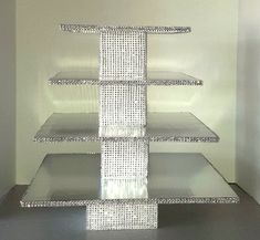 three tiered glass display case in a white room