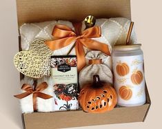 an open box with some items in it and a pumpkin on the inside, sitting next to a cup