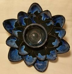 a blue and black flower shaped dish sitting on top of a table