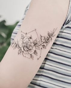 a woman with a tattoo on her arm that has roses and stars around it,