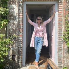 a woman standing in an open doorway with her arms up