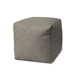 a small square grey ottoman sitting on top of a white floor next to a wall