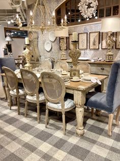 the dining room table is set with blue chairs and white plates on top of it