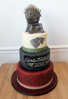 a three tiered cake with a game of throne on top