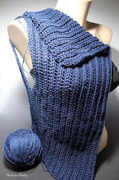 a blue knitted shawl and ball of yarn on a mannequin's head