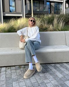 a woman sitting on top of a cement bench