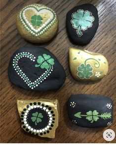 four painted rocks with shamrocks and hearts on them