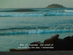 a person laying on the beach looking out at the ocean