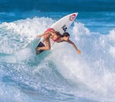 a woman riding a wave on top of a surfboard