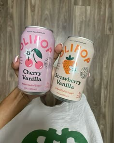 two cans of yogurt sitting on top of a white t - shirt