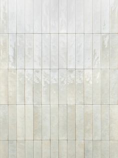 a white tiled wall with no one standing on the floor or sitting in front of it