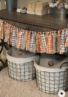 two buckets are sitting on the floor next to a table with books and other items