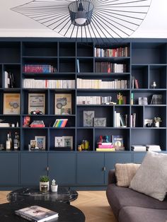 a living room filled with lots of bookshelves next to a couch and coffee table