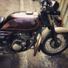 a brown and black motorcycle parked next to a building