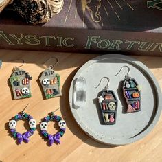 some earrings are sitting on a table next to a book and other items in front of it