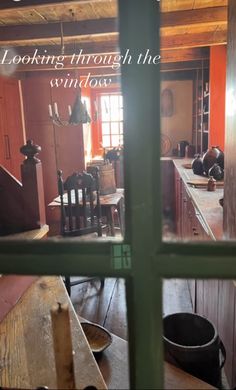 looking through the window at an old fashioned kitchen and dining room with wooden furniture in it