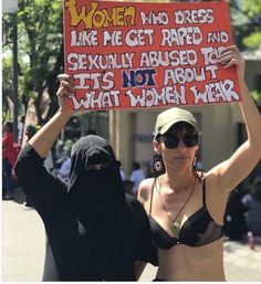 two women in bikinis holding up a sign that says women are not allowed to work