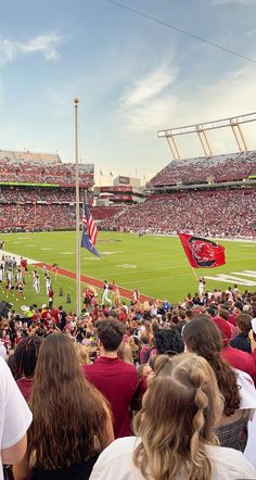 a stadium filled with lots of people watching a football game on a sunny day in the sun