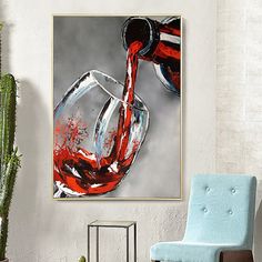 red wine being poured into a glass in front of a white wall with a blue chair