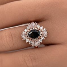 a woman's hand with a black and white diamond ring on top of her finger