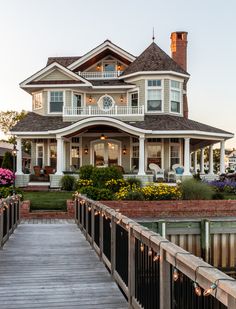 a large white house sitting on top of a wooden bridge