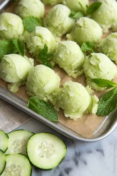 cucumber and mint ice cream on a baking sheet next to sliced cucumbers