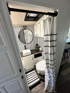 a bathroom with black and white striped shower curtain