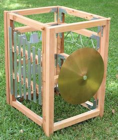 a wooden box with a gong in it on the grass