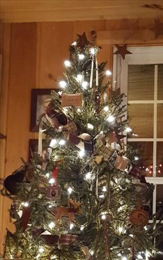 a decorated christmas tree in front of a window