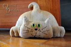 a cat figurine sitting on top of a wooden table next to a box